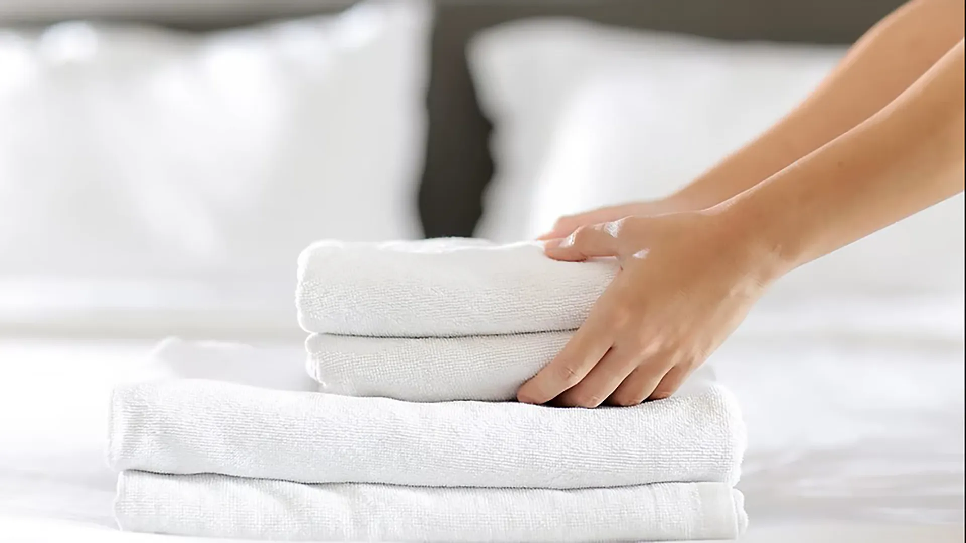photo of folded towels being placed in a stack